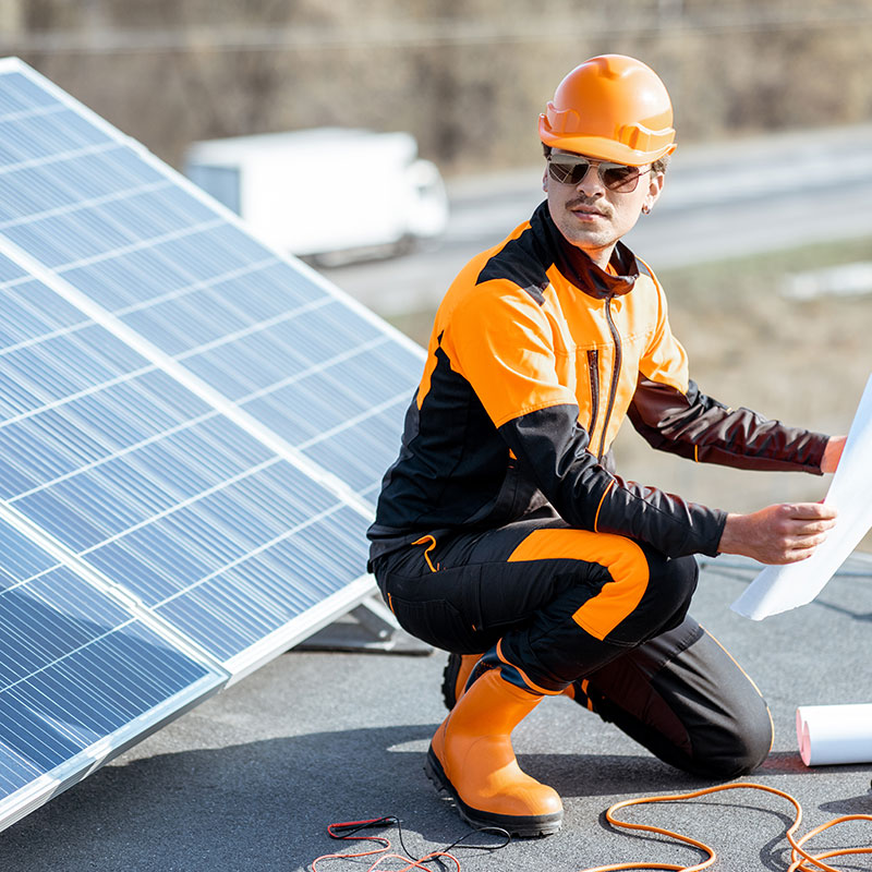 Technician cleaning solar panels on a residential roof with ocean view, Gold Coast."